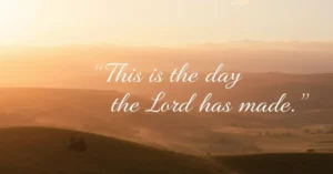 Sunrise shining over green hills with the words “This is the day the Lord has made” written across the sky